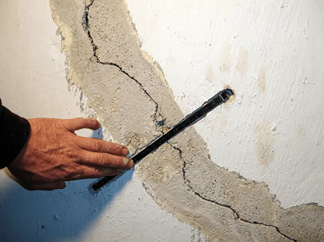 A wall with a large crack is being inspected by a professional in Las Vegas, NV